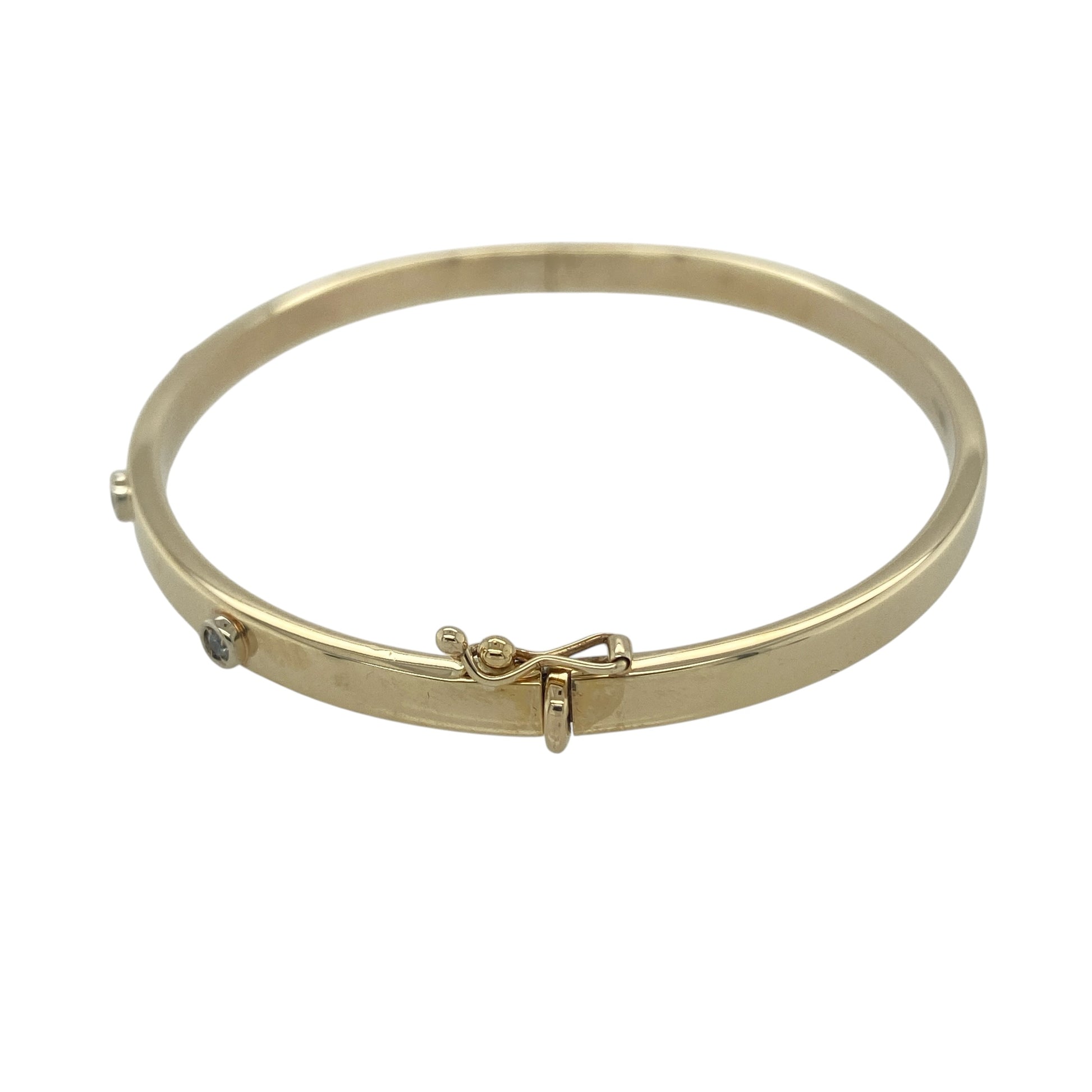 Add timeless elegance and subtle sparkle to your jewellery collection with this pre-owned 9ct yellow gold diamond set hinged bangle. Featuring four sparkling diamonds across the front and a classic polished gold finish, this sophisticated bangle is perfect for everyday luxury or special occasions.

Design: The bangle showcases a sleek and refined profile with a 4mm wide band, accented by four sparkling diamonds positioned across the front.