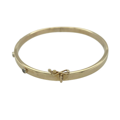 Add timeless elegance and subtle sparkle to your jewellery collection with this pre-owned 9ct yellow gold diamond set hinged bangle. Featuring four sparkling diamonds across the front and a classic polished gold finish, this sophisticated bangle is perfect for everyday luxury or special occasions.

Design: The bangle showcases a sleek and refined profile with a 4mm wide band, accented by four sparkling diamonds positioned across the front.