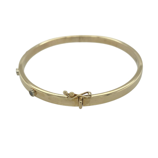 Add timeless elegance and subtle sparkle to your jewellery collection with this pre-owned 9ct yellow gold diamond set hinged bangle. Featuring four sparkling diamonds across the front and a classic polished gold finish, this sophisticated bangle is perfect for everyday luxury or special occasions.

Design: The bangle showcases a sleek and refined profile with a 4mm wide band, accented by four sparkling diamonds positioned across the front.