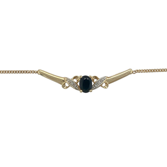 Add timeless elegance and vibrant colour to your jewellery collection with this pre-owned 9ct yellow gold diamond and sapphire necklace. Featuring a beautiful oval sapphire framed by sparkling diamonds on a graceful curved bar design, this sophisticated necklace is perfect for both everyday wear and special occasions.

Design: The necklace showcases an elegant curved bar centrepiece featuring an oval-cut sapphire measuring approximately 7mm by 5mm.