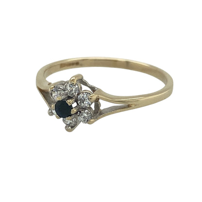 Add a touch of floral elegance and vibrant colour to your jewellery collection with this pre-owned 9ct yellow gold sapphire and cubic zirconia flower cluster ring. Featuring a delicate flower-inspired design with a rich blue sapphire centre, this charming ring offers timeless appeal and everyday wearability.

Design: The ring showcases a beautiful flower cluster design centred around a round sapphire measuring approximately 2mm in diameter.