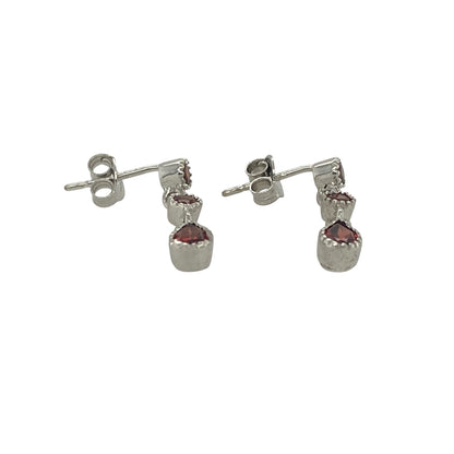Add a touch of rich colour and elegant movement to your jewellery collection with these pre-owned 9ct white gold three-stone garnet drop earrings. Featuring beautifully matched garnets suspended in a graceful drop design, these earrings offer timeless sophistication and striking visual appeal.

Design: The earrings showcase a classic drop style, each set with three garnet gemstones arranged in a flowing vertical design.