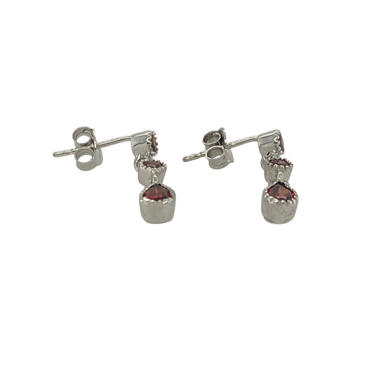 Add a touch of rich colour and elegant movement to your jewellery collection with these pre-owned 9ct white gold three-stone garnet drop earrings. Featuring beautifully matched garnets suspended in a graceful drop design, these earrings offer timeless sophistication and striking visual appeal.

Design: The earrings showcase a classic drop style, each set with three garnet gemstones arranged in a flowing vertical design.