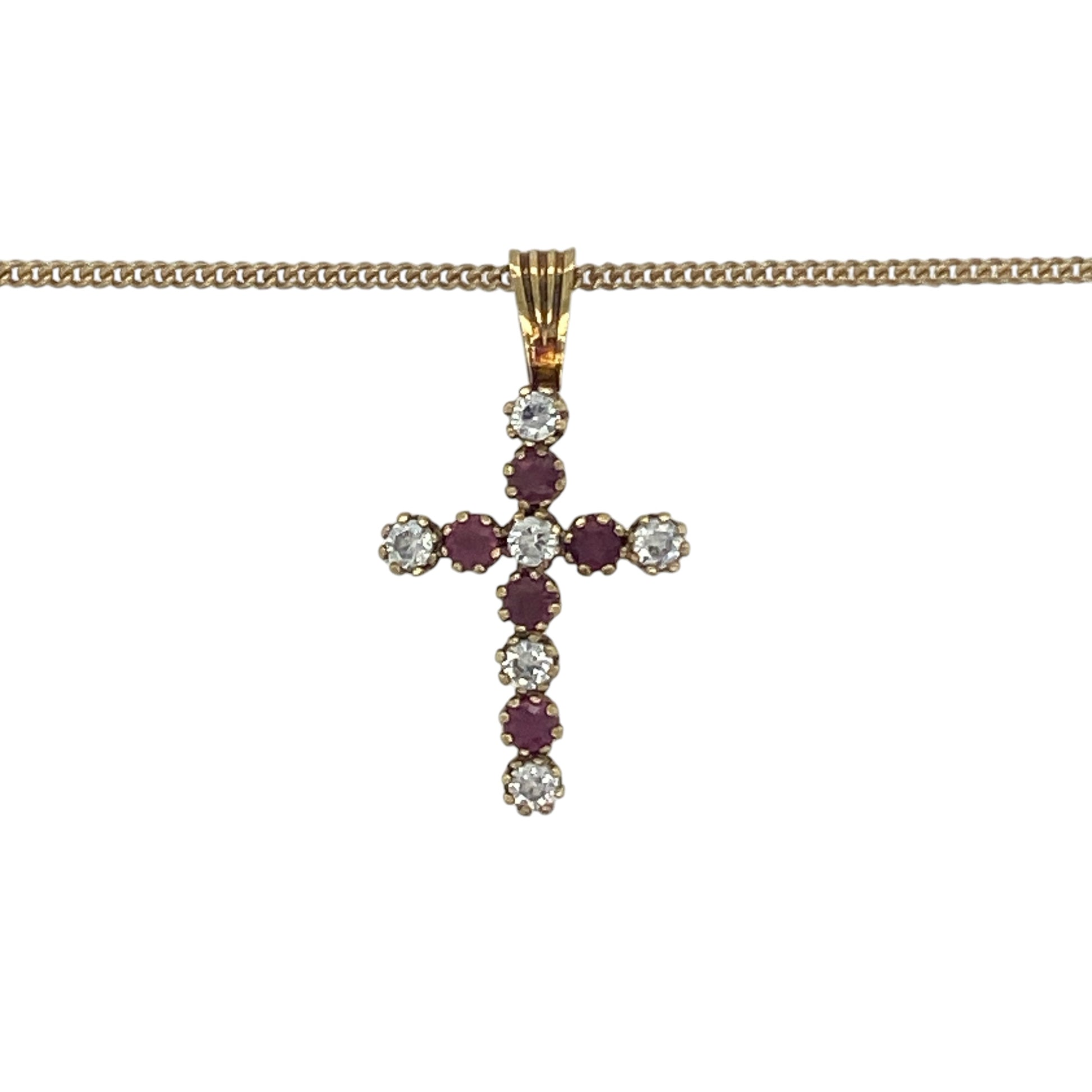 Elegant and meaningful, this pre-owned 9ct yellow gold ruby and cubic zirconia cross pendant necklace beautifully combines timeless Christian symbolism with vibrant colour and sparkling brilliance. Suspended from a classic curb chain, it is a graceful piece suitable for everyday wear or special occasions.

Design: The necklace features a classic cross pendant measuring approximately 2.2cm in length, including the bail.
