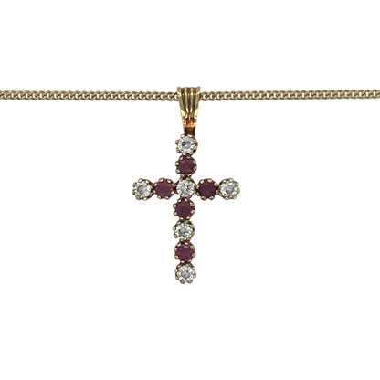 Elegant and meaningful, this pre-owned 9ct yellow gold ruby and cubic zirconia cross pendant necklace beautifully combines timeless Christian symbolism with vibrant colour and sparkling brilliance. Suspended from a classic curb chain, it is a graceful piece suitable for everyday wear or special occasions.

Design: The necklace features a classic cross pendant measuring approximately 2.2cm in length, including the bail.