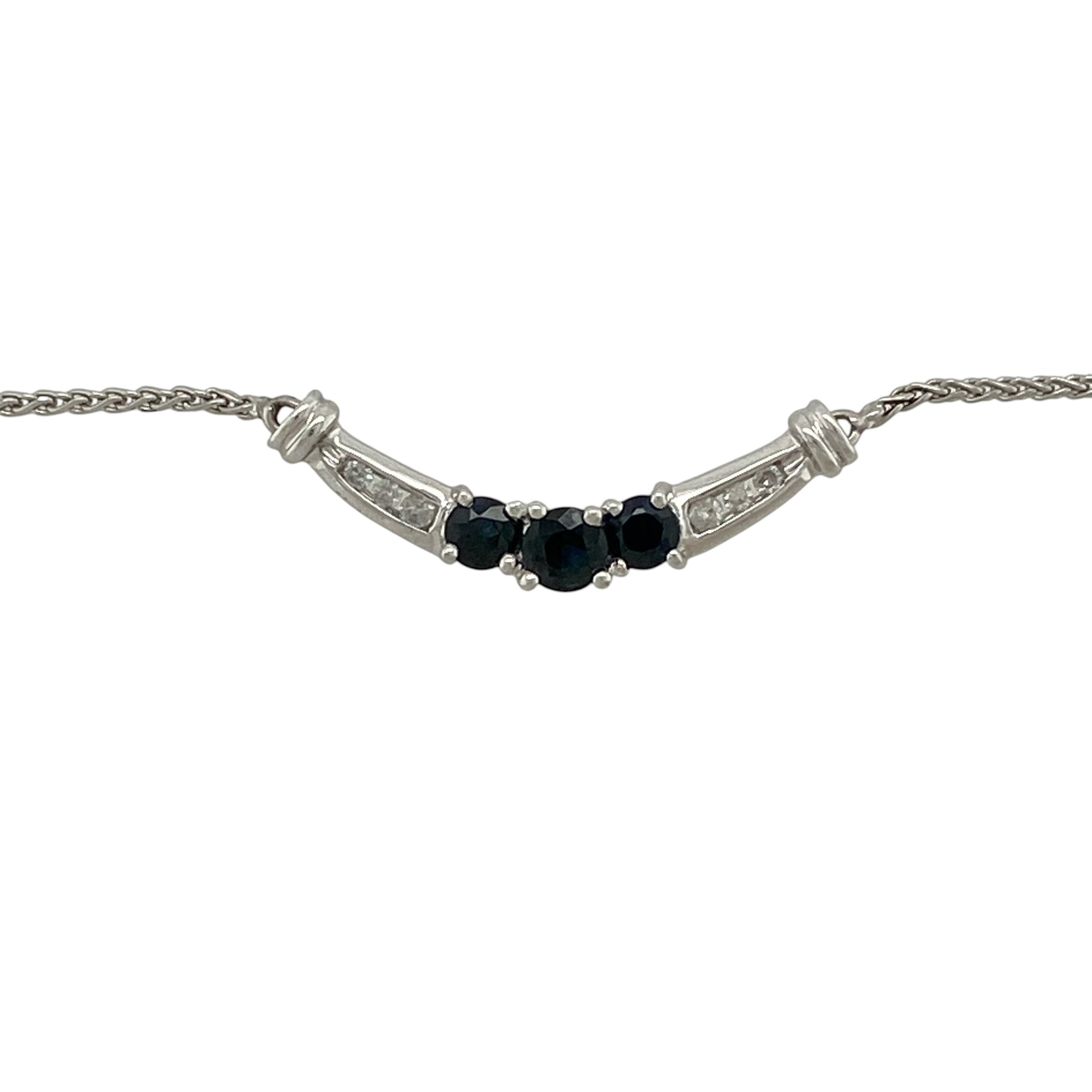 Add timeless elegance and vibrant colour to your jewellery collection with this pre-owned 10ct white gold diamond and sapphire curved bar necklace, featuring a graceful arrangement of sapphires and sparkling diamonds—perfect for everyday sophistication or special occasions.

Design: The necklace showcases an elegant curved bar design with a round sapphire measuring approximately 4mm in diameter at the centre, flanked by two round sapphires measuring approximately 3mm in diameter.