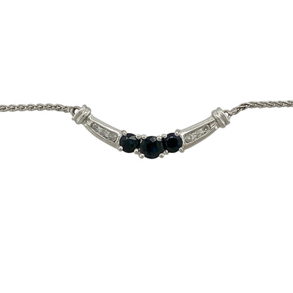 Add timeless elegance and vibrant colour to your jewellery collection with this pre-owned 10ct white gold diamond and sapphire curved bar necklace, featuring a graceful arrangement of sapphires and sparkling diamonds—perfect for everyday sophistication or special occasions.

Design: The necklace showcases an elegant curved bar design with a round sapphire measuring approximately 4mm in diameter at the centre, flanked by two round sapphires measuring approximately 3mm in diameter.