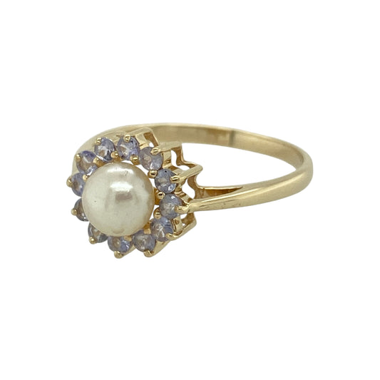 Add timeless elegance and delicate colour to your jewellery collection with this pre-owned 9ct yellow gold pearl and tanzanite cluster ring, featuring a lustrous pearl surrounded by sparkling tanzanite gemstones—perfect for special occasions or everyday sophistication.

Design: The ring showcases a beautiful cultured pearl measuring approximately 6mm in diameter, surrounded by a cluster of vibrant tanzanite stones.