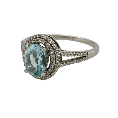 Add exceptional sparkle to your jewellery collection with this pre-owned 9ct white gold diamond and blue stone ring, featuring a striking oval blue centre stone framed by two rows of dazzling diamonds.

Design: The ring showcases a vibrant oval blue centre stone measuring approximately 8mm by 6mm, surrounded by a luxurious double halo of sparkling diamonds that enhance its brilliance and create an impressive statement.