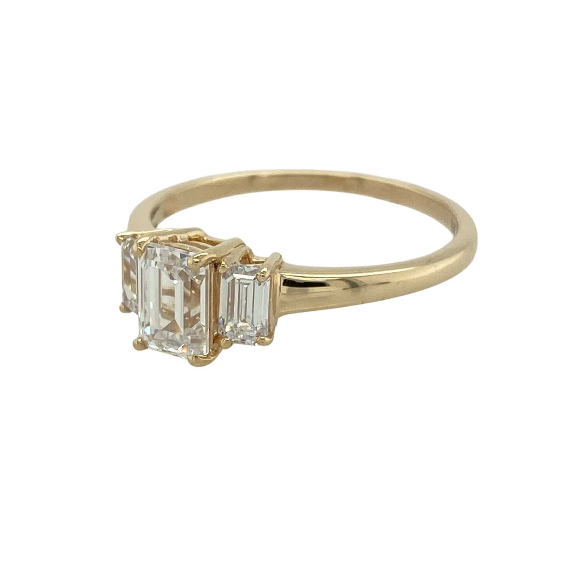 Add classic sparkle to your jewellery collection with this pre-owned 9ct yellow gold cubic zirconia trilogy ring, featuring three elegant stones in a timeless design.

Design: The ring showcases a striking rectangular centre cubic zirconia stone measuring approximately 7mm by 5mm, complemented by a stone on either side to create a classic trilogy arrangement. The three-stone design offers beautiful sparkle and an elegant presence on the finger, making it suitable for everyday wear or special occasions.