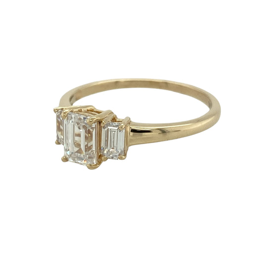 Add classic sparkle to your jewellery collection with this pre-owned 9ct yellow gold cubic zirconia trilogy ring, featuring three elegant stones in a timeless design.

Design: The ring showcases a striking rectangular centre cubic zirconia stone measuring approximately 7mm by 5mm, complemented by a stone on either side to create a classic trilogy arrangement. The three-stone design offers beautiful sparkle and an elegant presence on the finger, making it suitable for everyday wear or special occasions.