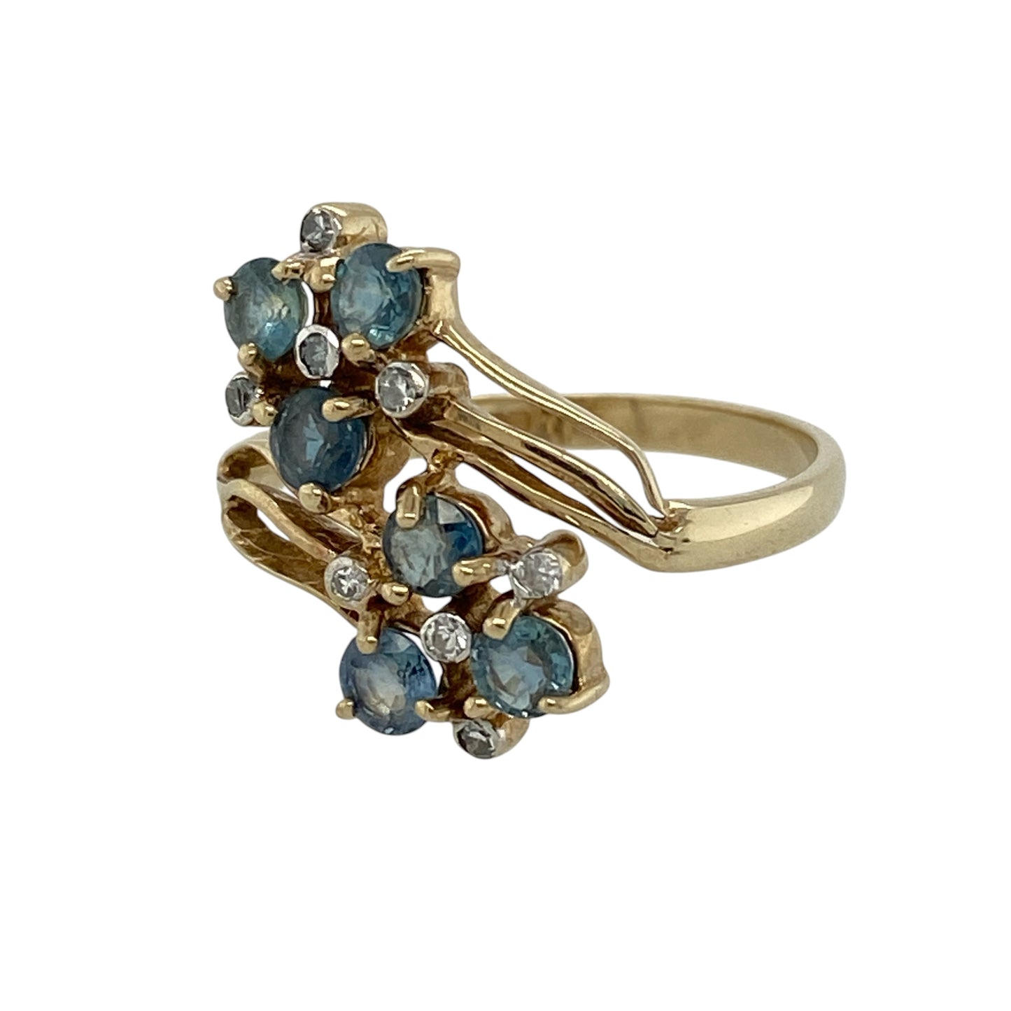 Add vibrant colour and vintage-inspired elegance to your jewellery collection with this pre-owned 9ct yellow gold diamond and sapphire double cluster flower twist ring, featuring a distinctive floral design with an eye-catching profile.

Design: The ring showcases an elegant double flower cluster arrangement set within a graceful twist-style design. The two floral clusters create an attractive statement across the finger, while the flowing twist setting adds movement and distinctive character.