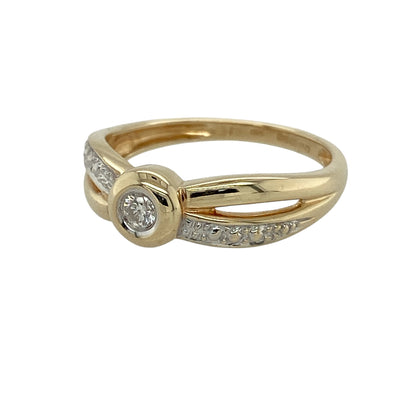 Add classic elegance and contemporary two-tone styling to your jewellery collection with this pre-owned 9ct yellow gold diamond rubover-set solitaire ring, featuring distinctive white gold crossover shoulder detailing.

Design: The ring showcases an elegant solitaire design centred around a sparkling diamond secured within a smooth rubover setting.