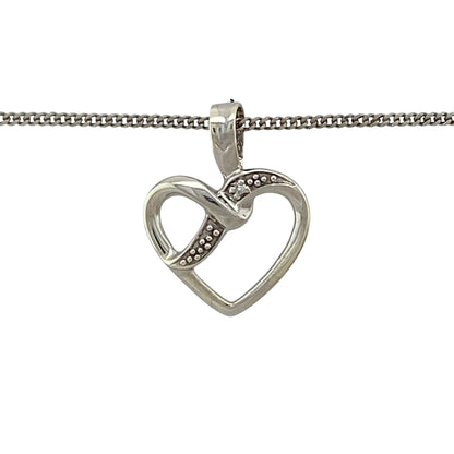 Add romantic symbolism and delicate sparkle to your jewellery collection with this pre-owned 9ct white gold and diamond open heart pendant necklace, featuring an elegant design with timeless appeal.

Design: The necklace showcases a graceful open heart pendant enhanced with diamond detailing and suspended from a classic 18-inch curb chain, creating a romantic and versatile design suitable for everyday wear or special occasions.