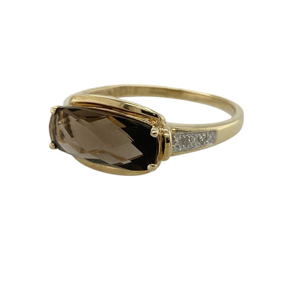 Add warm gemstone colour and elegant sparkle to your jewellery collection with this pre-owned 9ct yellow gold diamond and smoky quartz ring, featuring a striking elongated quartz stone complemented by diamond-set shoulders.

Design: The ring showcases an elegant gemstone design centred around a substantial smoky quartz stone, enhanced with diamond-set shoulders that add subtle sparkle and visual interest.