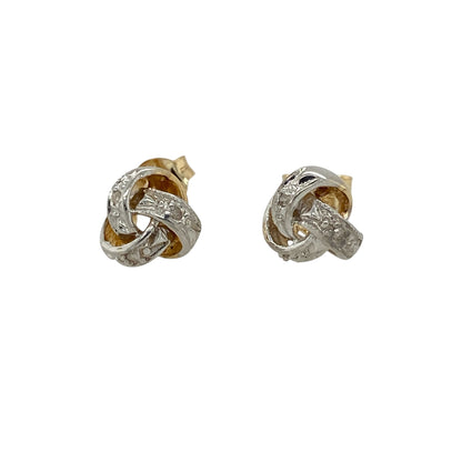 Add timeless elegance and refined sparkle to your jewellery collection with these pre-owned 9ct yellow and white gold diamond knot stud earrings, featuring a classic intertwined design with versatile two-tone styling.

Design: The earrings showcase an elegant knot design formed from intertwined yellow and white gold elements, creating an attractive sense of depth and movement enhanced with subtle diamond sparkle.