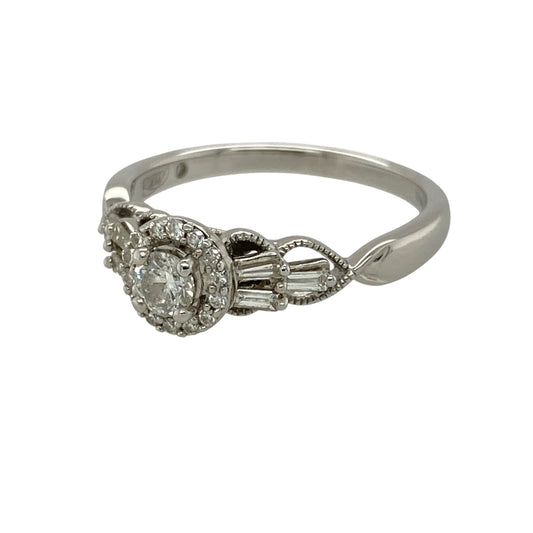Add elegant sparkle and sophisticated diamond detailing to your jewellery collection with this pre-owned 18ct white gold and diamond halo cluster ring, featuring a brilliant cut diamond halo complemented by baguette cut diamonds set along the shoulders.

Design: The ring showcases an elegant halo cluster design with brilliant cut diamonds forming the central halo and baguette cut diamonds adding distinctive geometric detail along the shoulders.