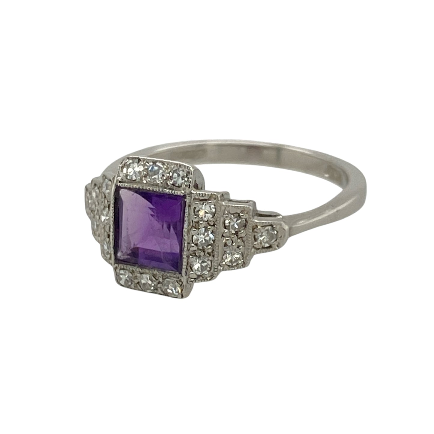Add rich gemstone colour and vintage-inspired elegance to your jewellery collection with this pre-owned 18ct white gold diamond and amethyst ring, featuring a square amethyst framed by an Art Deco style diamond surround.

Design: The ring showcases an elegant Art Deco inspired design centred around a square amethyst, complemented by a decorative diamond surround that creates a distinctive geometric appearance with vintage-style appeal.