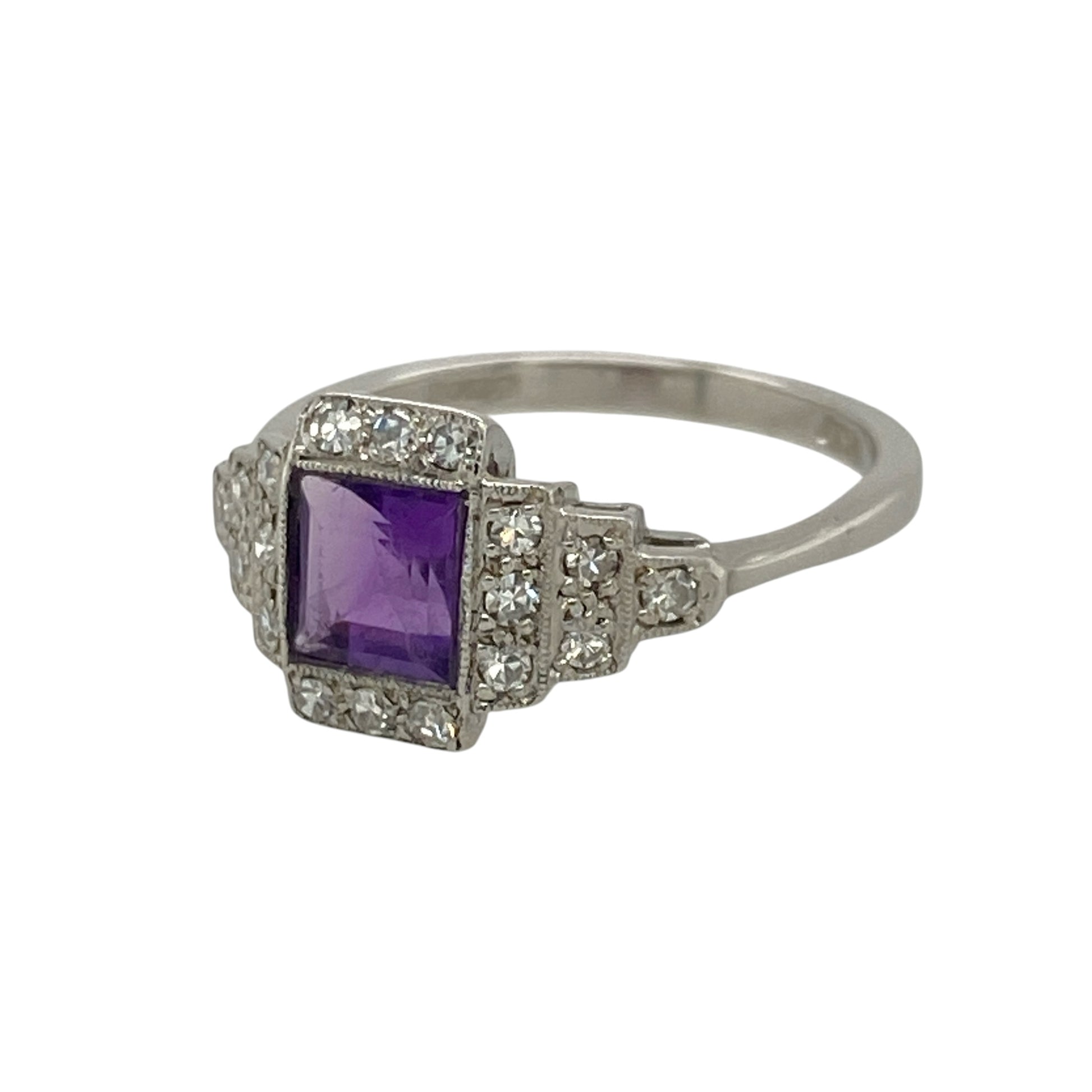 Add rich gemstone colour and vintage-inspired elegance to your jewellery collection with this pre-owned 18ct white gold diamond and amethyst ring, featuring a square amethyst framed by an Art Deco style diamond surround.

Design: The ring showcases an elegant Art Deco inspired design centred around a square amethyst, complemented by a decorative diamond surround that creates a distinctive geometric appearance with vintage-style appeal.