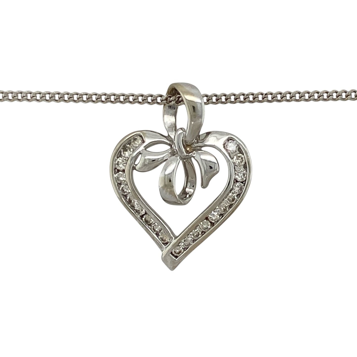 Add romantic styling and elegant sparkle to your jewellery collection with this pre-owned 9ct white gold and diamond open heart bow pendant necklace, featuring a decorative design suspended from a classic curb chain.

Design: The pendant showcases an elegant open heart profile enhanced with a bow-inspired design and diamond detailing, creating a romantic and decorative appearance with timeless appeal.