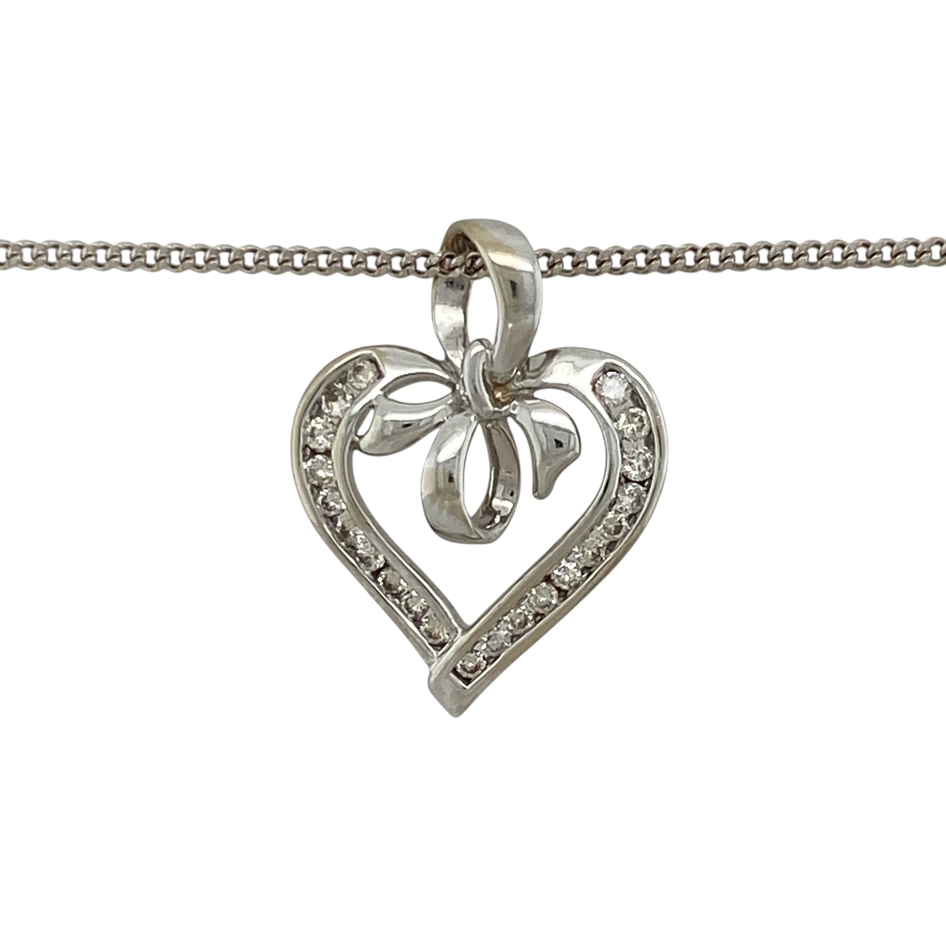 Add romantic styling and elegant sparkle to your jewellery collection with this pre-owned 9ct white gold and diamond open heart bow pendant necklace, featuring a decorative design suspended from a classic curb chain.

Design: The pendant showcases an elegant open heart profile enhanced with a bow-inspired design and diamond detailing, creating a romantic and decorative appearance with timeless appeal.