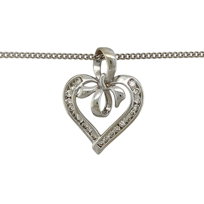 Add romantic styling and elegant sparkle to your jewellery collection with this pre-owned 9ct white gold and diamond open heart bow pendant necklace, featuring a decorative design suspended from a classic curb chain.

Design: The pendant showcases an elegant open heart profile enhanced with a bow-inspired design and diamond detailing, creating a romantic and decorative appearance with timeless appeal.