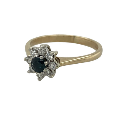 Celebrate timeless elegance with this pre-owned 9ct yellow gold diamond and sapphire cluster ring. Featuring a rich blue sapphire surrounded by sparkling diamonds, this classic design is perfect for everyday wear or adding a touch of sophistication to any occasion.

Design: The ring showcases a round sapphire at its centre, framed by a cluster of sparkling diamonds that enhance the vibrant blue gemstone and create a timeless look.