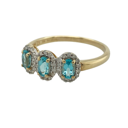 This pre-owned 9ct yellow gold diamond and blue stone trilogy cluster ring is an eye-catching design, combining vibrant blue gemstones with sparkling diamond surrounds.

Design: The ring features three oval blue stones arranged in a classic trilogy setting, with each gemstone framed by a halo of diamonds for added brilliance. The timeless cluster design makes it a beautiful choice for both everyday wear and special occasions.
Material: Made from 9-carat yellow gold.