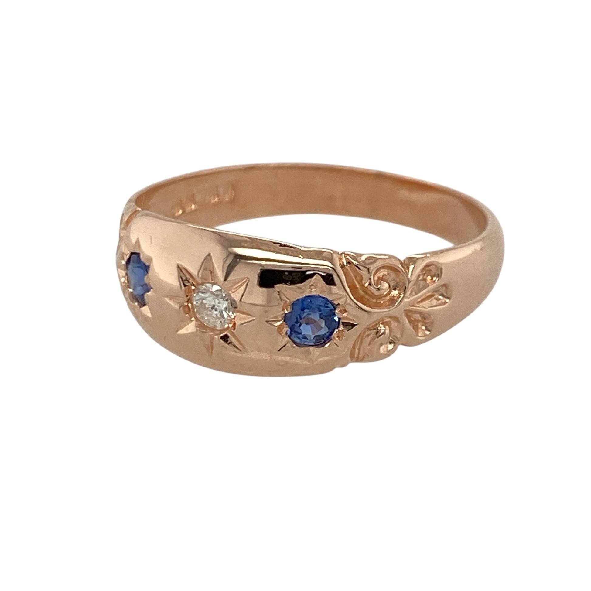 This pre-owned 9ct rose gold diamond and sapphire vintage style band ring combines classic elegance with intricate vintage-inspired detailing.

Design: The ring features a vintage style band with a sparkling centre diamond framed by deep blue sapphires. The beautifully detailed 7mm wide front creates an eye-catching look, making it an ideal choice for everyday wear or special occasions.
Material: Made from 9-carat rose gold.