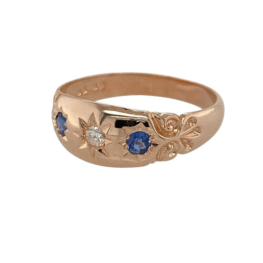 This pre-owned 9ct rose gold diamond and sapphire vintage style band ring combines classic elegance with intricate vintage-inspired detailing.

Design: The ring features a vintage style band with a sparkling centre diamond framed by deep blue sapphires. The beautifully detailed 7mm wide front creates an eye-catching look, making it an ideal choice for everyday wear or special occasions.
Material: Made from 9-carat rose gold.