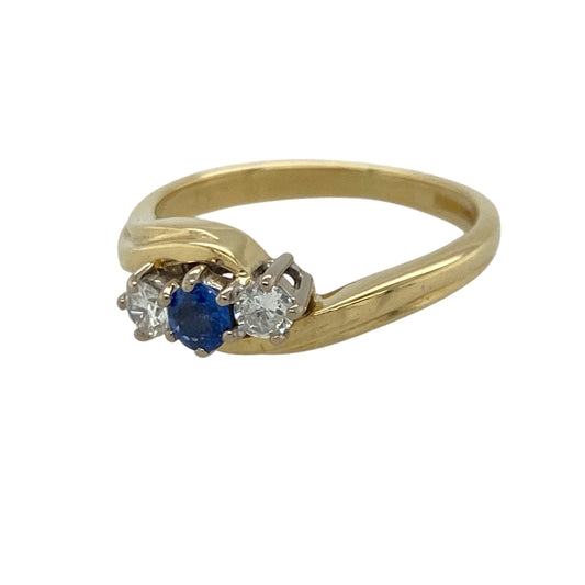 This pre-owned 18ct yellow gold diamond and sapphire trilogy twist ring is a timeless design, combining a rich blue sapphire with sparkling diamonds in an elegant twisted setting.

Design: The ring features a round centre sapphire with a brilliant diamond on either side, all held within a graceful twist design that enhances the classic trilogy style. The combination of deep blue sapphire and bright diamonds creates a sophisticated look suitable for any occasion.