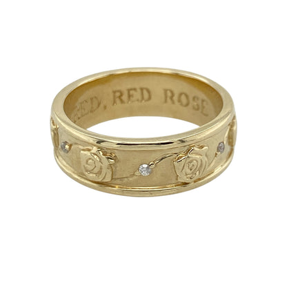 This pre-owned 9ct yellow gold diamond rose flower patterned band ring is a beautifully detailed piece, combining floral design with subtle diamond accents.

Design: The 6mm wide band is decorated with an intricate pattern of rose flowers all the way around, with a small sparkling diamond set between each rose. The continuous floral design creates a unique and eye-catching ring, perfect for everyday wear or as a distinctive wedding or eternity band.
Material: Made from 9-carat yellow gold.