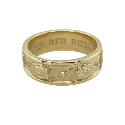 This pre-owned 9ct yellow gold diamond rose flower patterned band ring is a beautifully detailed piece, combining floral design with subtle diamond accents.

Design: The 6mm wide band is decorated with an intricate pattern of rose flowers all the way around, with a small sparkling diamond set between each rose. The continuous floral design creates a unique and eye-catching ring, perfect for everyday wear or as a distinctive wedding or eternity band.
Material: Made from 9-carat yellow gold.