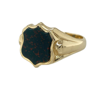 This pre-owned 9ct yellow gold bloodstone shield signet ring combines a traditional signet design with the distinctive natural beauty of bloodstone.

Design: The ring features a classic shield-shaped signet design set with a polished bloodstone, creating a timeless and bold appearance. The substantial yellow gold setting enhances the rich green tones and natural red flecks of the bloodstone, making it an eye-catching piece for everyday wear or special occasions.
Material: Made from 9-carat yellow gold.
