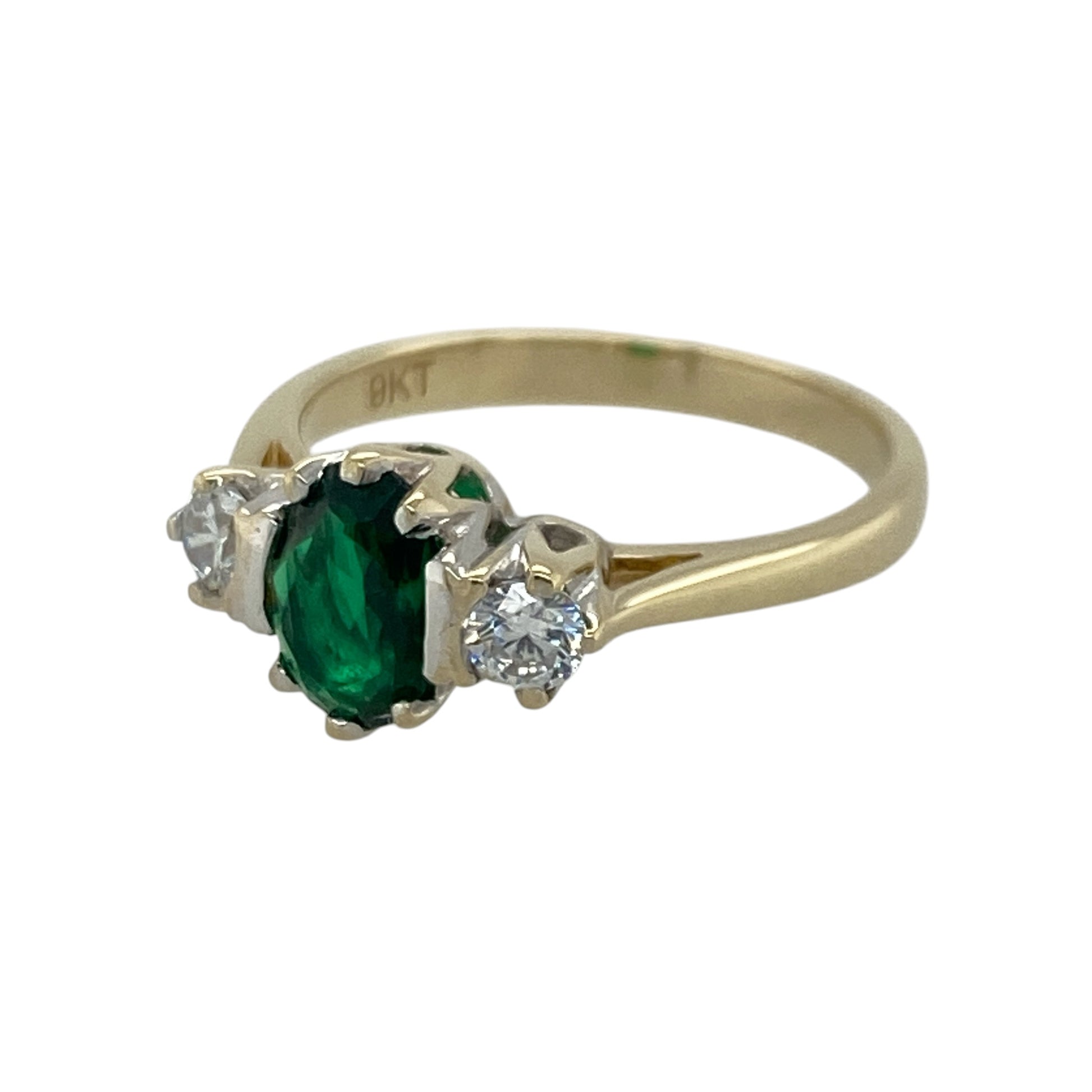 This pre-owned 9ct yellow gold green stone and cubic zirconia trilogy ring features a classic three-stone design with a vibrant green centre stone framed by sparkling cubic zirconias.

Design: The ring showcases an elegant trilogy setting with an oval green centre stone flanked by a cubic zirconia on either side. The polished yellow gold band gives this timeless design a bright, sophisticated finish that is perfect for both everyday wear and special occasions.
Material: Made from 9-carat yellow gold.