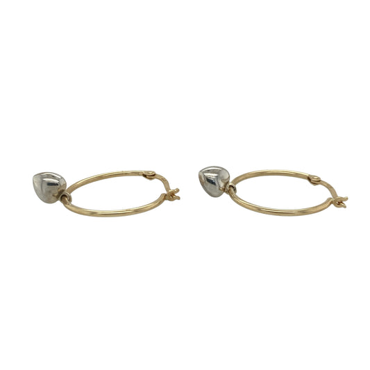This pair of pre-owned 9ct yellow gold hoop creole earrings features elegant white gold heart charms for a charming two-tone finish.

Design: These classic yellow gold hoop creole earrings are adorned with polished white gold heart charms, creating a beautiful contrast between the two precious metals. Their versatile design makes them perfect for everyday wear while adding a subtle romantic touch.
Material: Made from 9-carat yellow and white gold.