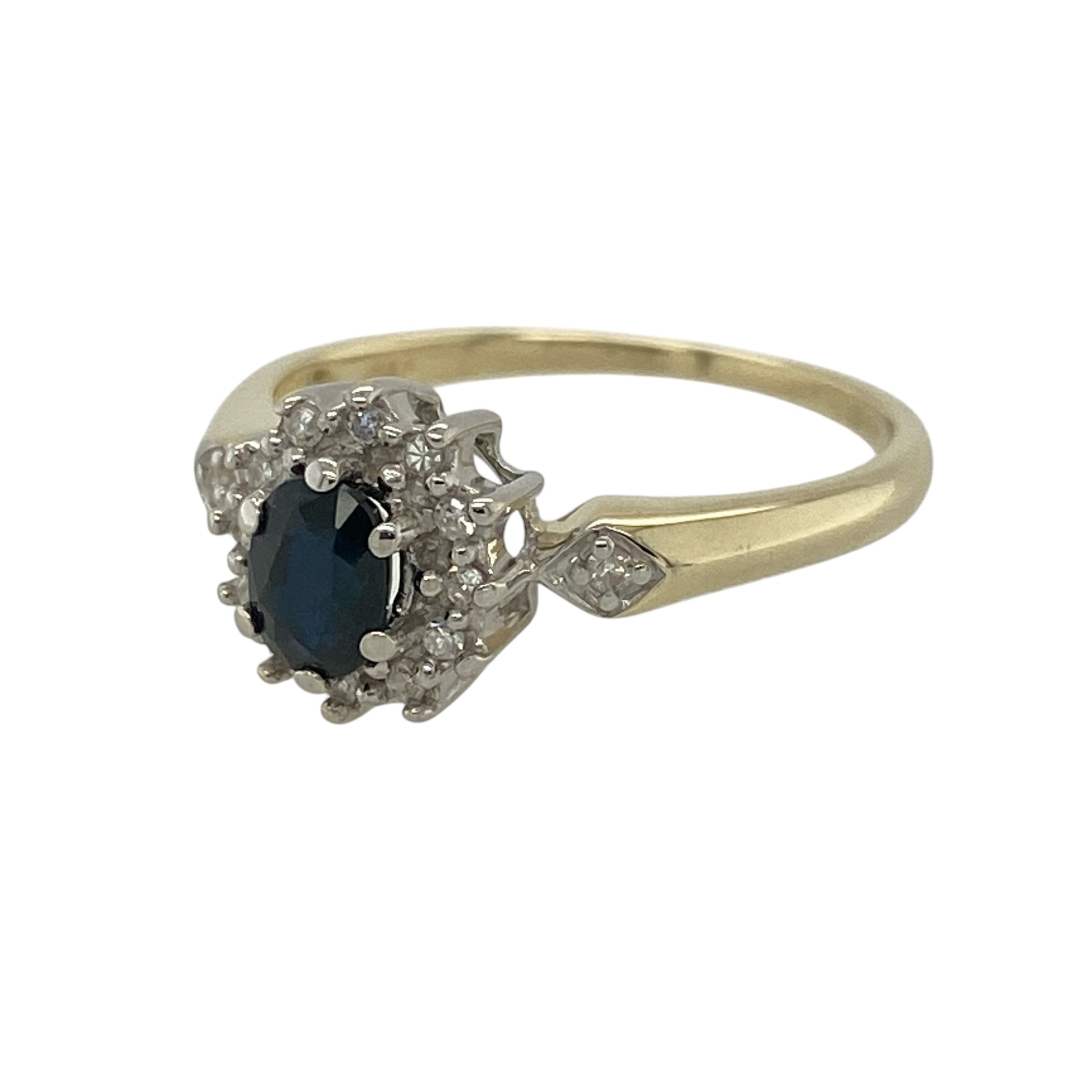 This pre-owned 9ct yellow gold diamond and sapphire cluster ring is a timeless piece, combining the rich blue beauty of sapphire with the brilliance of sparkling diamonds.

Design: Featuring an elegant oval sapphire surrounded by a halo of sparkling diamonds, this classic cluster ring offers a sophisticated and timeless look. Its refined design makes it perfect for everyday wear or as a special occasion piece.
Material: Made from 9-carat yellow gold.