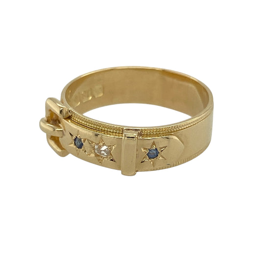 This pre-owned 18ct yellow gold diamond and sapphire buckle ring is a distinctive piece, combining classic gemstones with a timeless buckle design.

Design: Featuring an elegant buckle motif, this ring is set with sparkling diamonds and rich blue sapphires across the front, symbolising strength, loyalty and enduring love. The substantial band measures approximately 6mm wide, while the buckle detail measures approximately 7mm wide, creating a bold yet refined appearance.