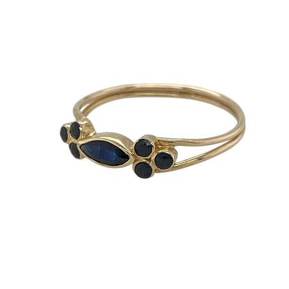 This pre-owned 9ct yellow gold sapphire ring is a delicate and elegant piece, showcasing a graceful marquise centre stone with sparkling blue sapphire accents.

Design: Featuring a marquise cut sapphire at the centre, this elegant ring is complemented by three small round sapphires on each shoulder, creating a beautifully balanced and timeless design. Its slim profile makes it perfect for everyday wear or stacking with other favourite rings.
Material: Made from 9-carat yellow gold.