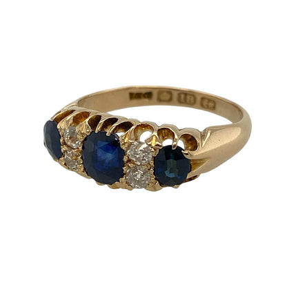 This pre-owned 18ct yellow gold diamond and sapphire vintage style ring is an elegant design, combining timeless craftsmanship with the rich beauty of sapphires and sparkling diamonds.

Design: Featuring a stunning oval sapphire at its centre, flanked by two matching oval sapphires with sparkling diamonds set in between, this vintage-inspired ring has a beautifully balanced and classic appearance.