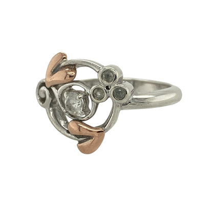 Elegant and symbolic, this pre-owned Clogau Tree of Life ring blends sterling silver, 9ct rose gold, and sparkling white topaz—perfect for meaningful style with a refined finish.

Design: The ring features a 3mm round white topaz stone at the centre, framed by a flowing Tree of Life design in 925 silver with delicate 9ct rose gold detailing.
Material: Made from sterling silver and 9-carat rose gold, the polished finish highlights the soft contrast between metals and the brilliance of the topaz.