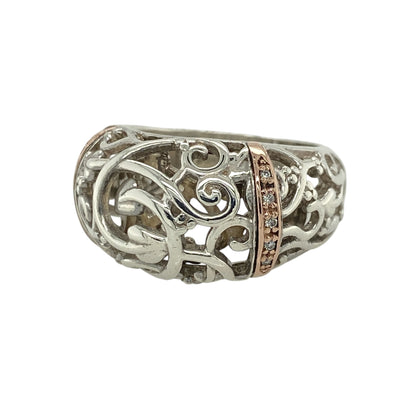 This pre-owned Clogau Tree of Life rounded band ring is a striking sterling silver and 9ct rose gold design, finished with sparkling diamond detail.

Design: Featuring Clogau’s iconic Tree of Life motif across a bold rounded band, this ring combines polished sterling silver with signature 9ct rose gold detailing and a sparkling diamond accent. Measuring approximately 13mm wide across the front, the substantial design beautifully showcases the flowing Tree of Life pattern inspired by Welsh heritage.