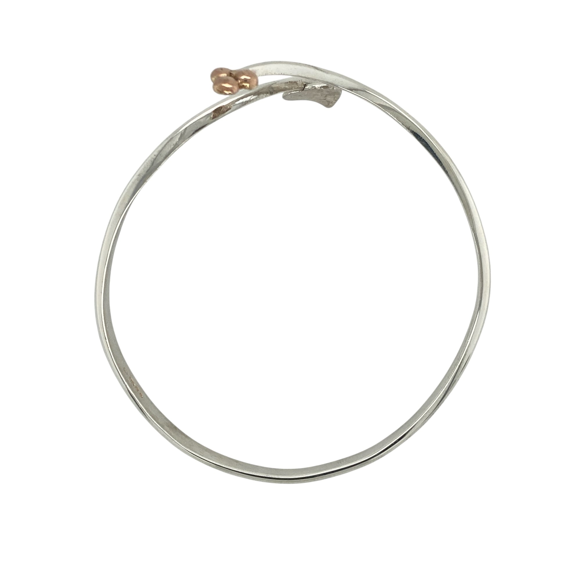 This pre-owned Clogau Tree of Life wrap around bangle is a beautiful sterling silver and 9ct rose gold design, featuring the iconic Tree of Life motif in an elegant open style.

Design: Featuring a stylish wrap around design decorated with Clogau’s distinctive Tree of Life detailing, this bangle combines polished sterling silver with signature 9ct rose gold accents for a timeless two-tone finish.