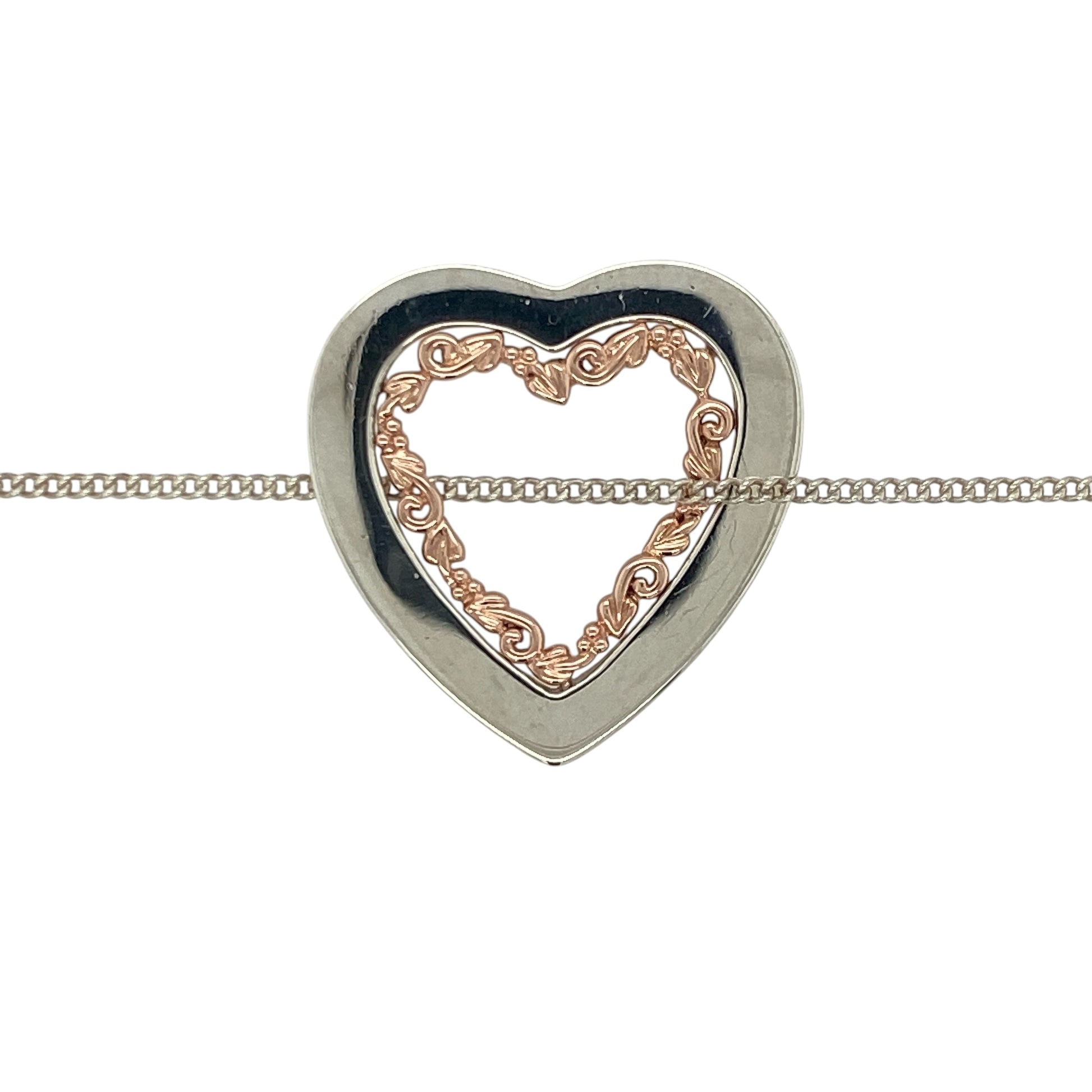 This pre-owned Clogau Tree of Life heart pendant necklace is a beautiful sterling silver and 9ct rose gold design, combining a romantic heart shape with the iconic Tree of Life motif.

Design: Featuring a heart-shaped pendant decorated with Clogau’s distinctive Tree of Life design, this necklace combines polished sterling silver with signature 9ct rose gold detailing for a timeless two-tone finish. The pendant measures approximately 26mm by 25mm and is suspended from an 18-inch Clogau curb chain.