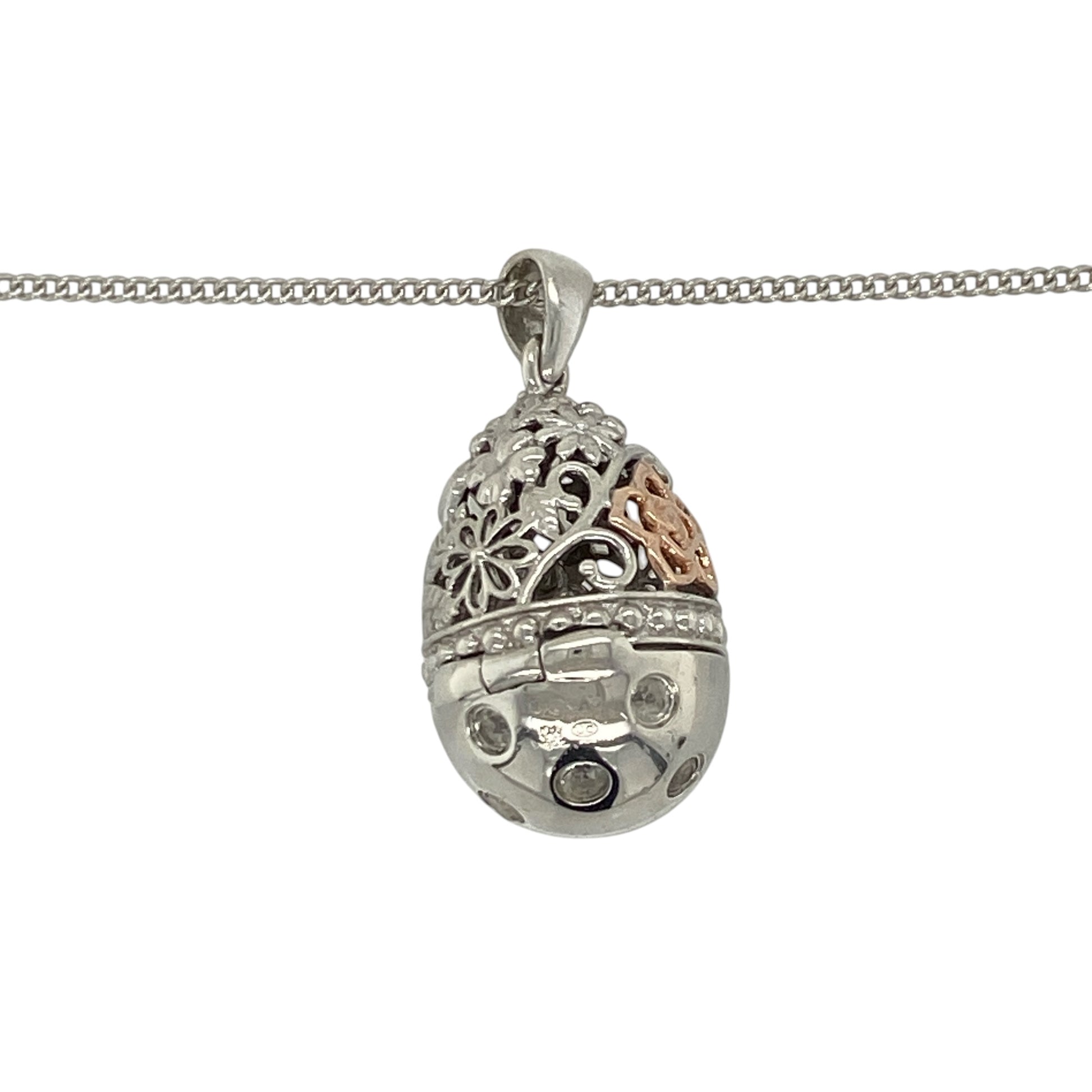 This pre-owned Clogau hinged egg pendant necklace is a distinctive sterling silver and 9ct rose gold design, featuring white topaz, floral detailing and a hidden heart drop inside.

Design: Featuring a patterned egg-shaped pendant decorated with floral detailing and sparkling white topaz, this Clogau design opens on a hinge to reveal a delicate heart drop hidden inside. The pendant measures approximately 2.7cm long including the bail and is suspended from an adjustable Clogau curb chain