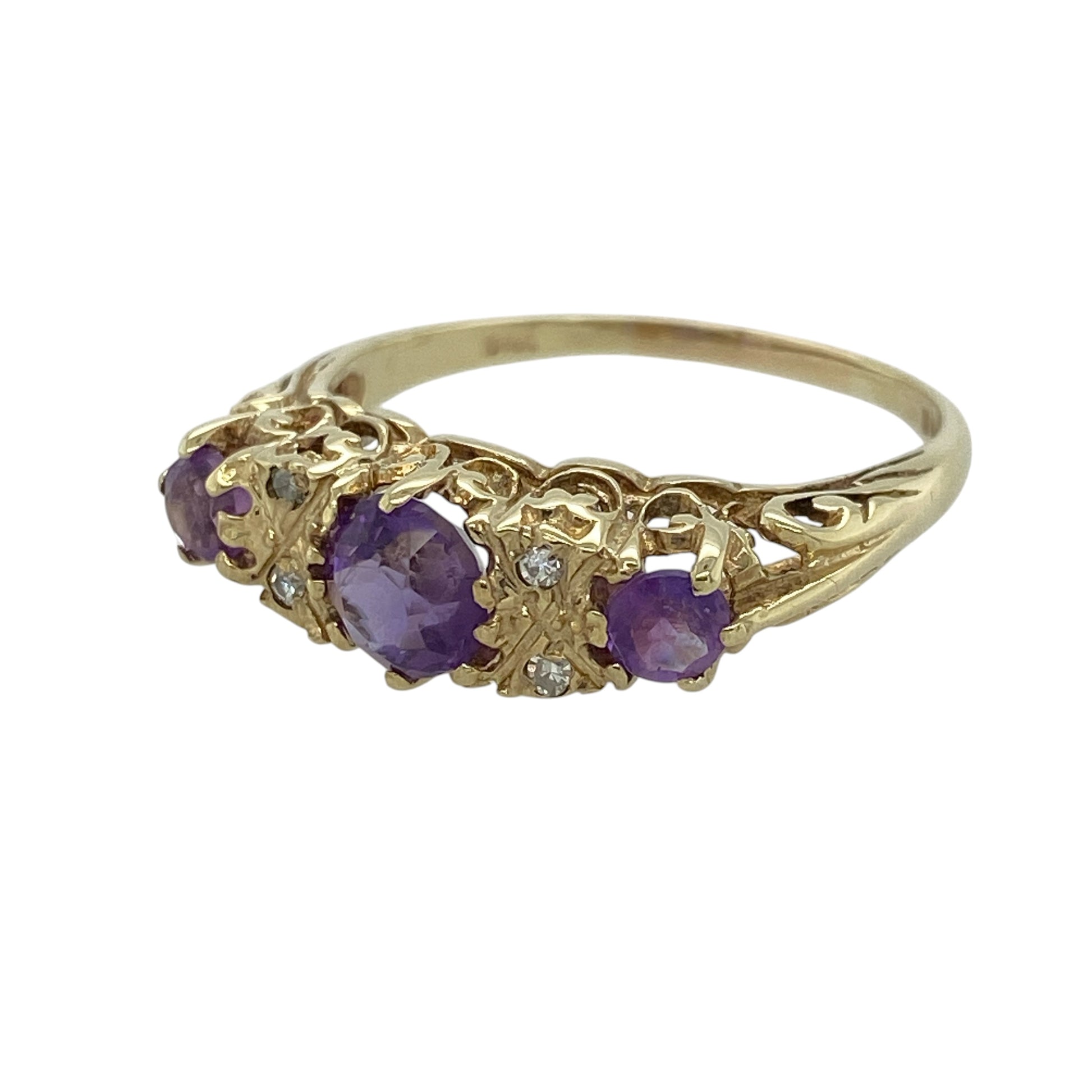 This pre-owned 9ct yellow gold diamond and amethyst vintage style ring is a decorative design, featuring three round amethyst stones with diamond detailing.

Design: Featuring a central round amethyst with two diamonds on either side and a round amethyst at each end, this ring has a vintage-inspired arrangement finished in warm 9ct yellow gold.
Material: Made from 9-carat yellow gold.
Gemstone Detail: Centre round amethyst measures approximately 5mm in diameter, with four diamonds and a round amethyst