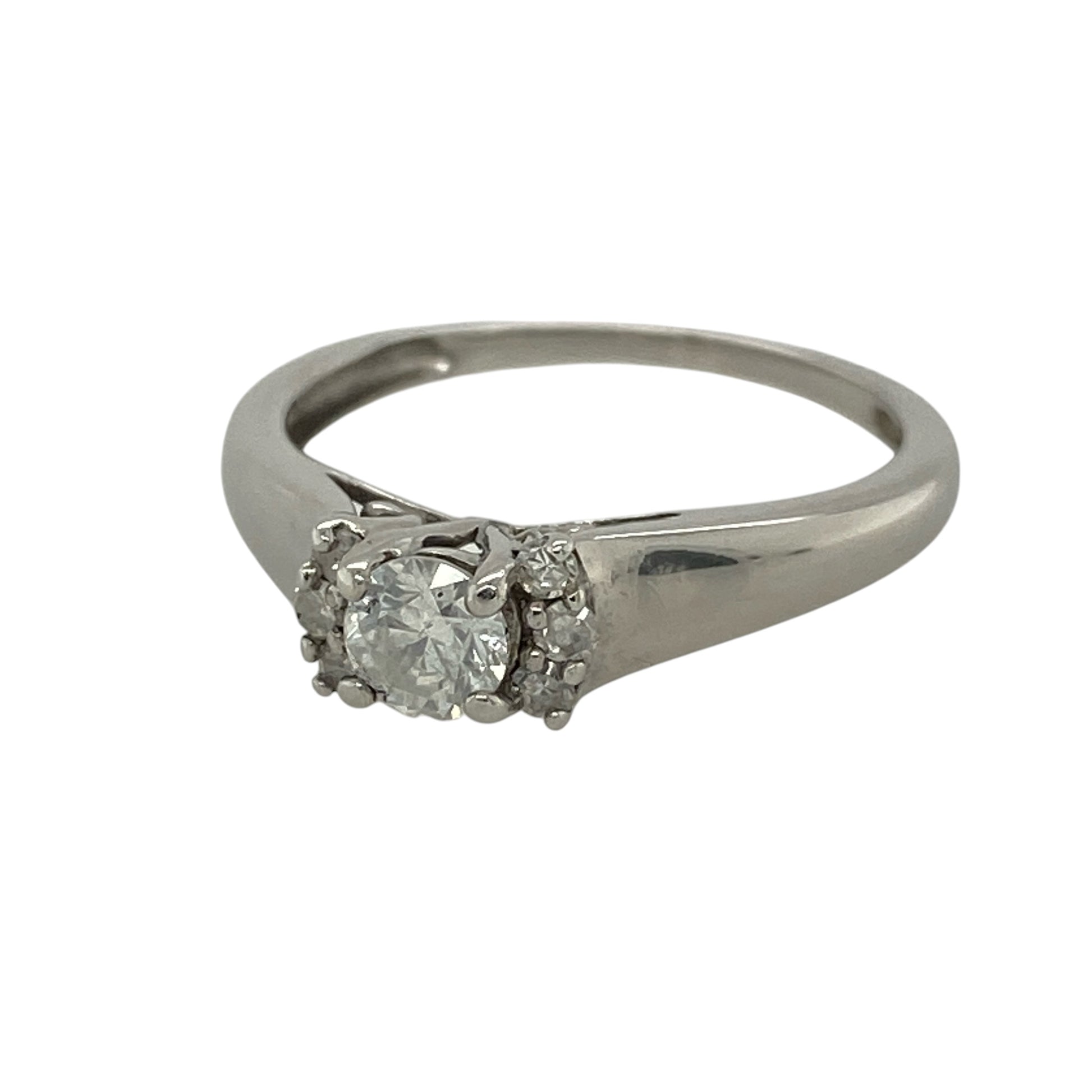 This pre-owned 18ct white gold diamond solitaire ring is an elegant design, featuring a brilliant cut centre diamond with smaller diamond detailing on either side.

Design: Featuring a brilliant cut centre diamond with six smaller diamonds around the setting, three on each side, this ring has a classic diamond-focused design finished in 18ct white gold.
Material: Made from 18-carat white gold.