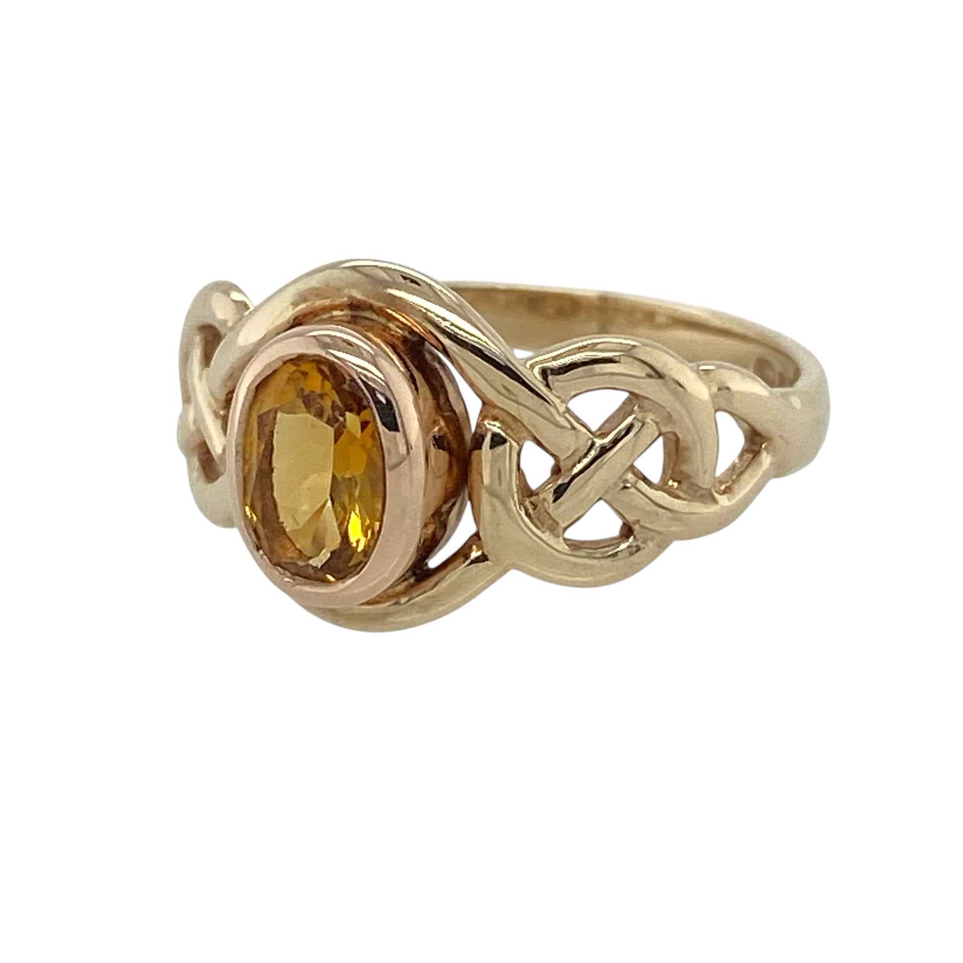 This pre-owned 9ct yellow and rose gold Clogau citrine birthstone ring is a distinctive Celtic-inspired design, featuring an oval citrine stone with contrasting gold detailing.

Design: Featuring a Celtic-inspired design in yellow and rose gold, this Clogau birthstone ring is centred with an oval citrine stone.
Material: Made from 9-carat yellow and rose gold.
Gemstone Detail: Oval citrine stone measuring approximately 6mm by 4mm.
Ring Detail: Clogau birthstone ring with Celtic-style detailing.