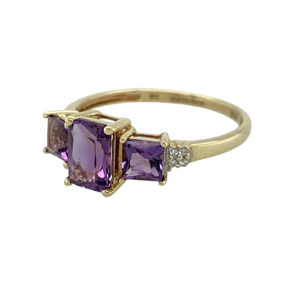 This pre-owned 9ct yellow gold diamond and amethyst trilogy ring is a colourful gemstone design, featuring three amethyst stones with diamond detailing.

Design: Featuring a rectangular centre amethyst with a square amethyst set on either side, this trilogy ring combines rich purple tones with diamond detailing and warm 9ct yellow gold.
Material: Made from 9-carat yellow gold.