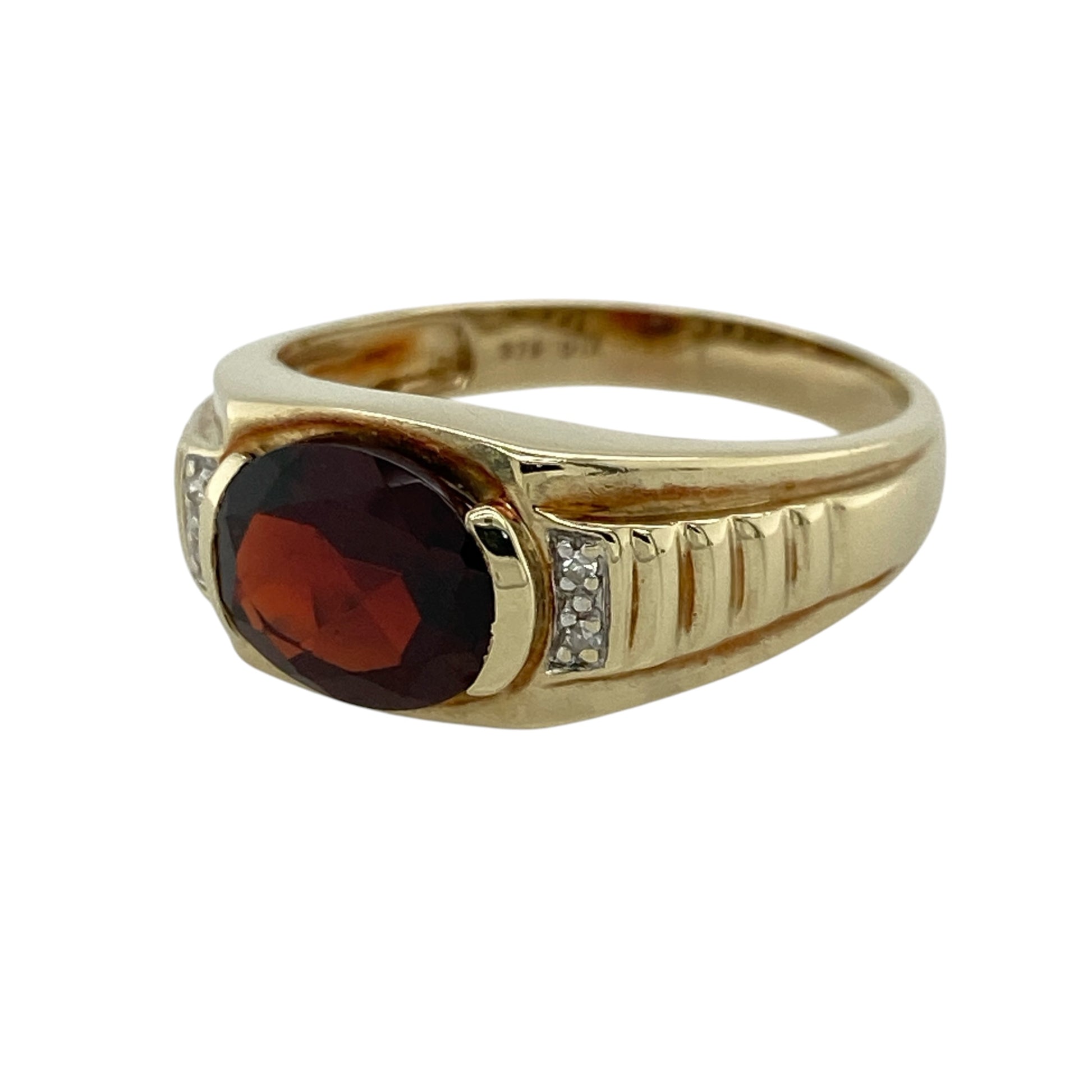This pre-owned 9ct yellow gold diamond and garnet watch-style ring is a distinctive gemstone design, featuring a large oval garnet with diamond detailing.

Design: Featuring a watch-style ring design centred with an oval garnet and diamond detailing, this ring combines rich red tones with the warm finish of 9ct yellow gold.
Material: Made from 9-carat yellow gold.
Gemstone Detail: Oval garnet stone measuring approximately 10mm by 8mm with diamond detailing.
Ring Detail: Decorative watch-style ring design.
